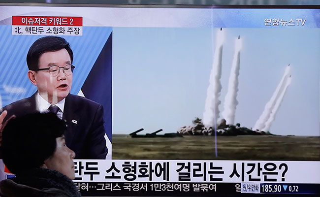 SEOUL. A woman passes by a TV screen showing a file footage of the missile launch conducted by North Korea at Seoul Railway Station in Seoul South Korea Thursday