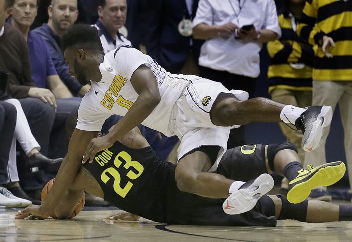 Oregon's Elgin Cook and California's Jaylen Brown dive for a loose ball in the first half of an NCAA college basketball game Thursday Feb. 11 2016 in Berkeley Calif