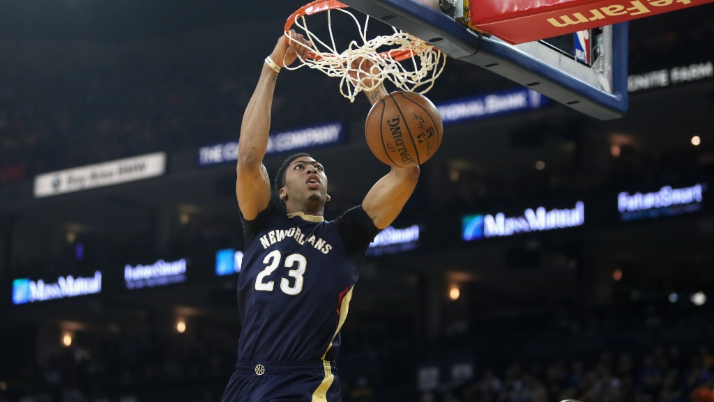 OAKLAND CA- MARCH 14 Anthony Davis #23 of the New Orleans Pelicans dunks the ball over Draymond Green #23 of the Golden State Warriors at ORACLE Arena