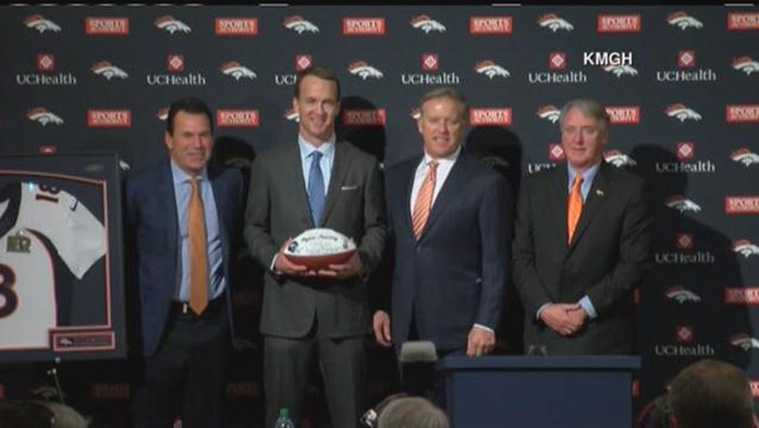 Peyton Manning and members of the Denver Broncos front office pose for