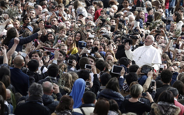 Pope Francis waves to the faithful during the Palm Sunday Mass in Saint Peter's Square at the Vatican