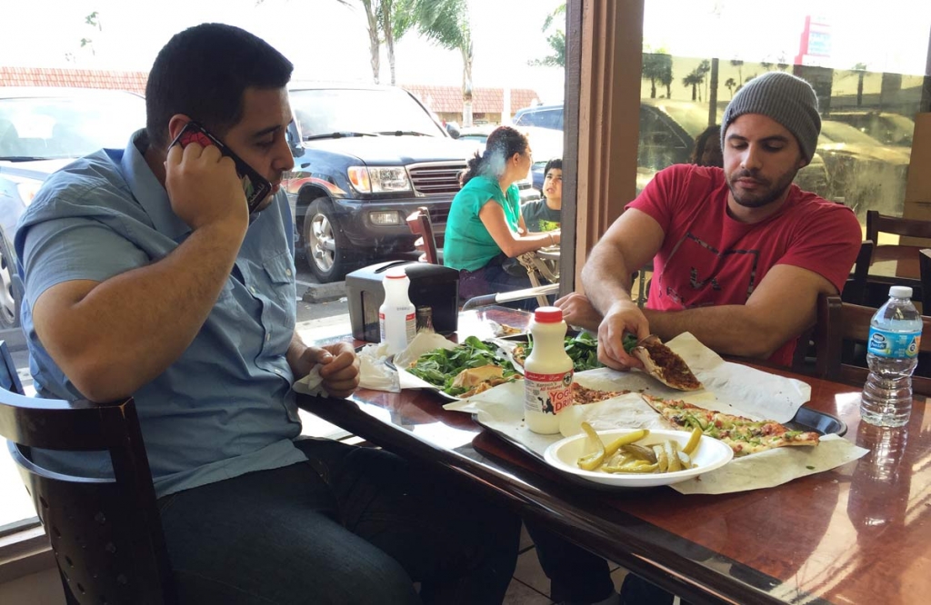 Nas Juma 22 left and Omar Ghanim 23 enjoy Lebanese pizza at Forn Al Hara restaurant in Orange County's Little Arabia in Anaheim Calif. Tuesday