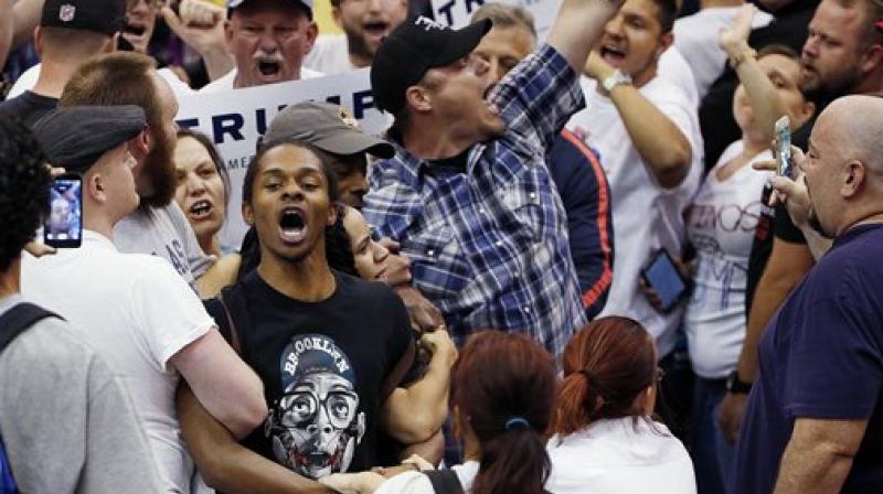 Protesters shout as they are removed from the venue as Republican presidential candidate Donald Trump speaks during a campaign rally