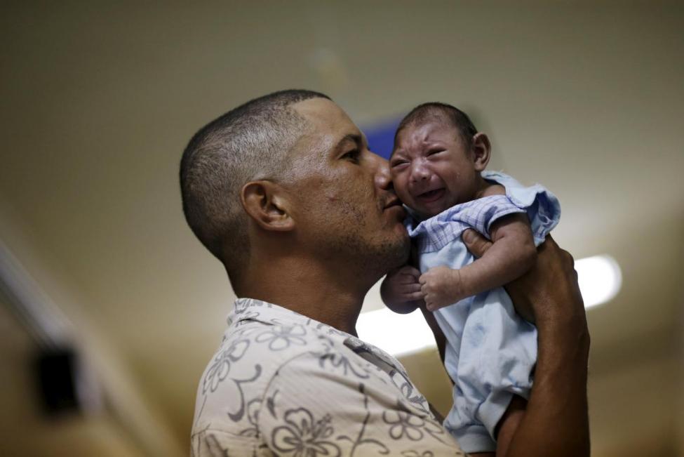 A Brazilian man holds his son who has microcephaly