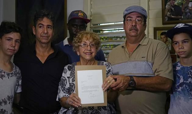 Ileana Yarza 76 center surrounded by her family holds a letter President Baracak Obama wrote to her as they pose for