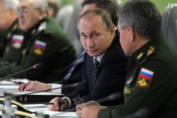 Russian President Vladimir Putin speaks with Defense Minister Sergei Shoiguas he attends a meeting with top military and military industry leaders in the Defense Ministry in iMoscow