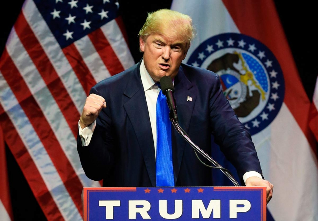 Republican presidential candidate Donald Trump describes how he was ready to punch a person who rushed the stage during an election rally earlier in the day as he speaks to a crowd in Kansas City Mo. Saturday