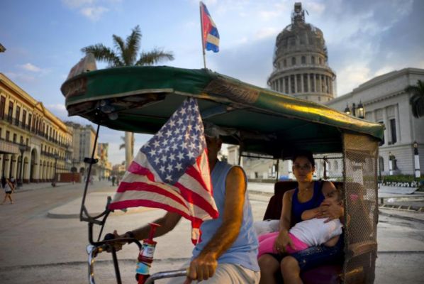 A taxi pedals his bicycle decorated with Cuban