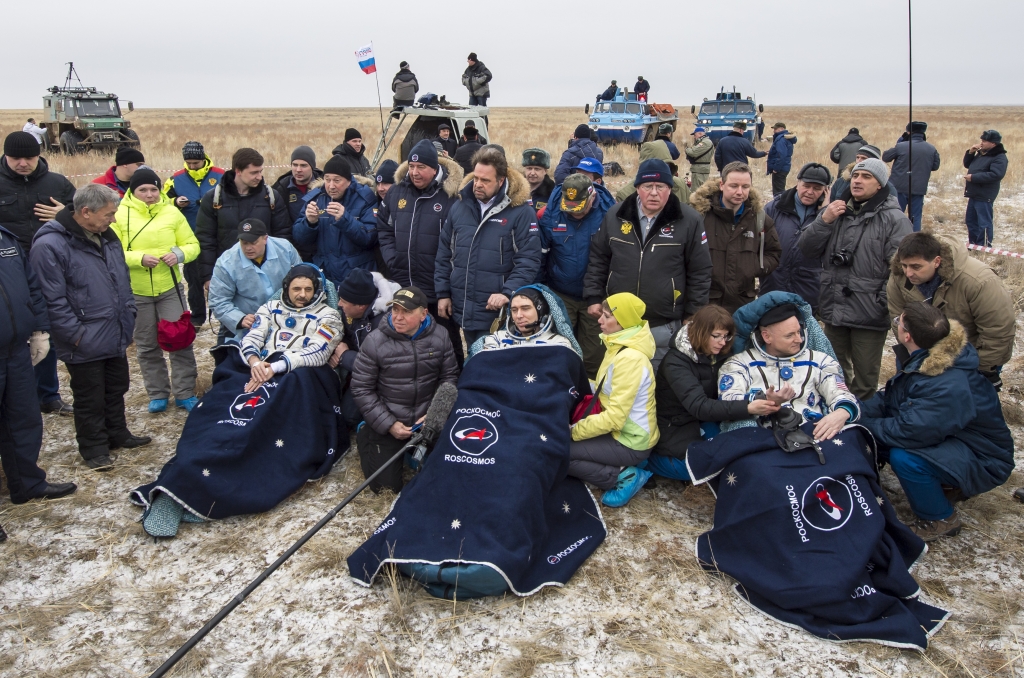 Russian cosmonauts Mikhail Kornienko left Sergey Volkov of Roscosmos center and Expedition 46 Commander Scott Kelly of NASA rest in a chairs outside of the Soyuz TMA-18M spacecraft minutes after landingin a remote area near Zhezkazgan Kazakhstan