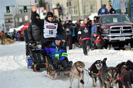 Defending Iditarod Trail Sled Dog Race champion Dallas Seavey waves to the crowd as she begins the ceremonial start of the 1,000-mile race in Anchorage Alaska