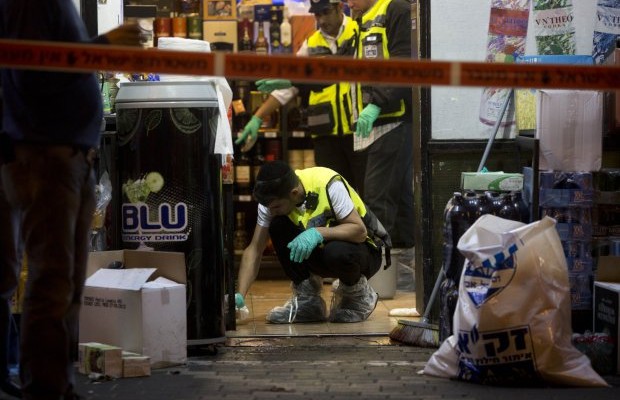 Israeli ZAKA emergency response members are seen at the scene of a stabbing attack in the central Israeli city of Petah Tikvah Tuesday