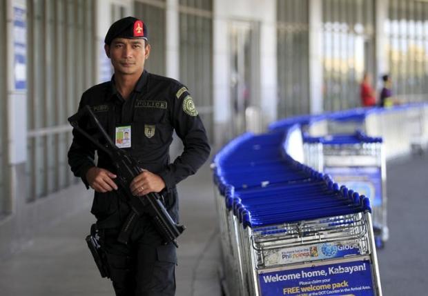 A member of the Philippine National Police aviation security group walks patrol outside of the Ninoy Aquino International Airport in Manila