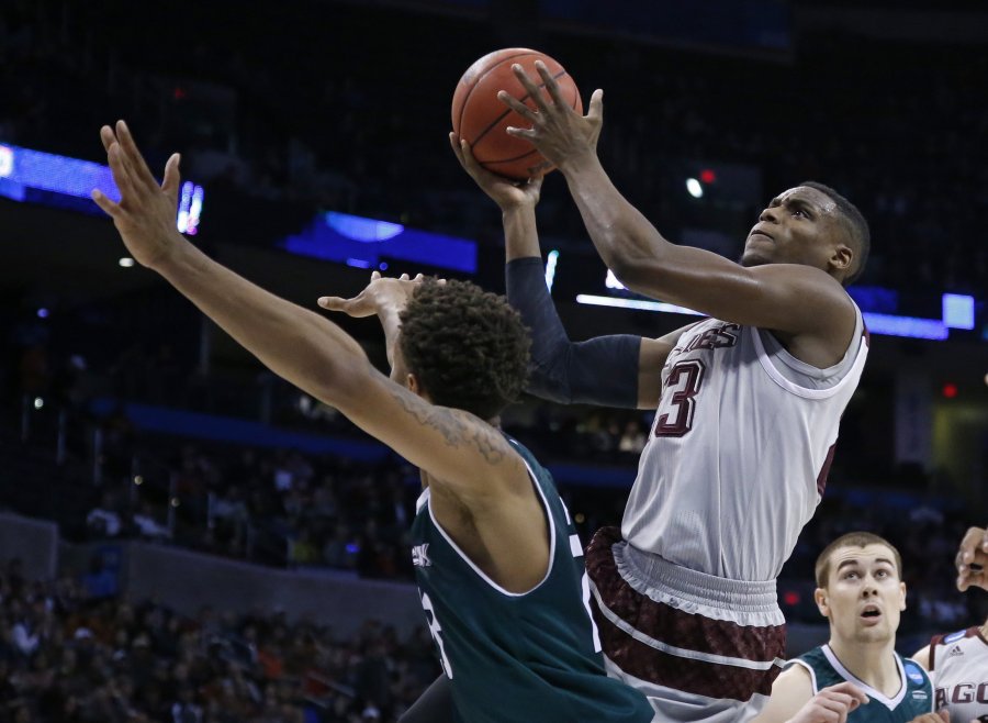 Texas A&M guard Danuel House shoots over Green Bay forward Jamar Hurdle in the first half of a first-round men