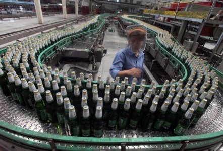 A labourer works at an assembly line in a factory of China Resources Snow Breweries Co. Ltd. in Lanzhou Gansu province