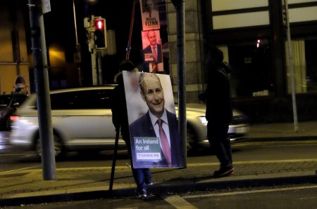 A man removes a campaign poster for Fianna Fail leader Micheal Martin after polling stations closed in Dublin Ireland