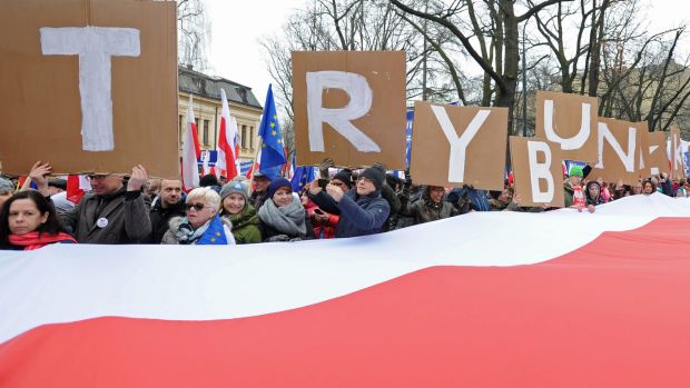 People hold placards with letters forming the word'Tribunal as thousands gather in front of the Constitutional