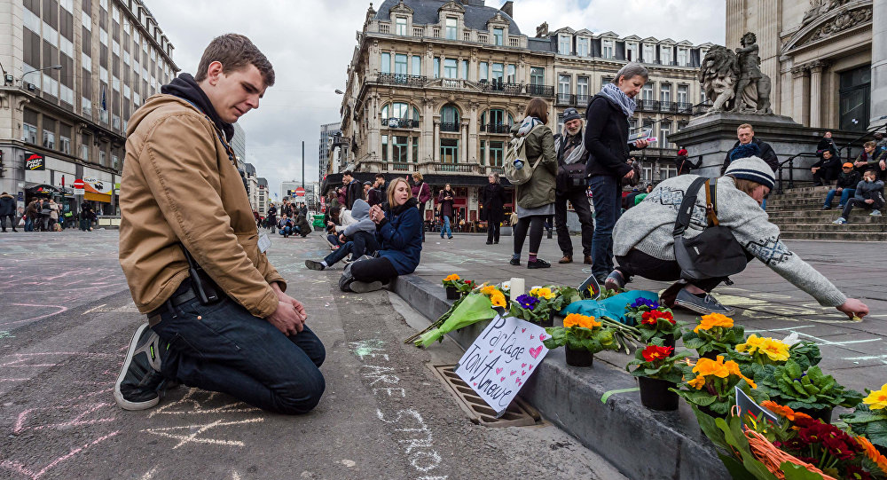 A man looks at flowers and messages outside the stock exchange in Brussels on Tuesday