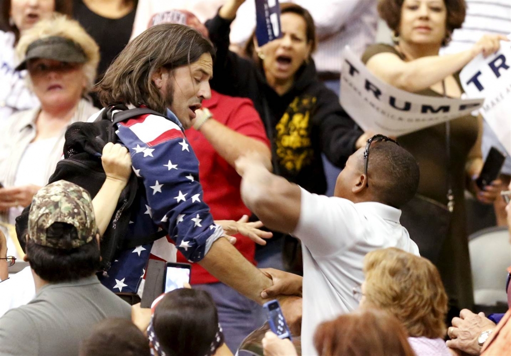 Image A member of the audience throws a punch at a protestor as Republican Presidential candidate Donald Trump speaks during a campaign event in Tucson