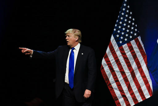 Republican presidential candidate Donald Trump points towards a demonstrator in the audience as he spoke at an election rally in Kansas City Mo