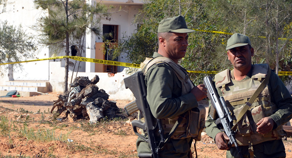 Tunisian soldiers stand guard at the scene of an assault on a house outside the town of Ben Guerdane near the border with Libya