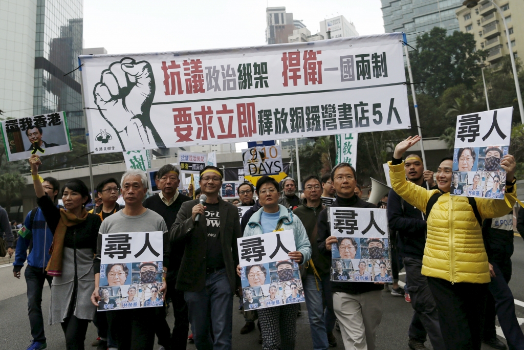 Demonstrators hold up portraits of five missing staff members of a publishing house and a bookstore during a protest over the disappearance of booksellers in Hong Kong China