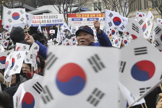 A South Korean war veteran waves a South Korean national flag during a rally against North Korea's rocket launch and nuclear test in Seoul South Korea Tuesday