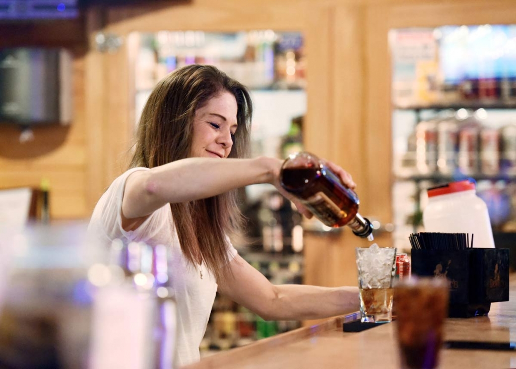 Jen Shaul a bartender at Buck's Saloon in Melba Idaho pours whiskey at the bar