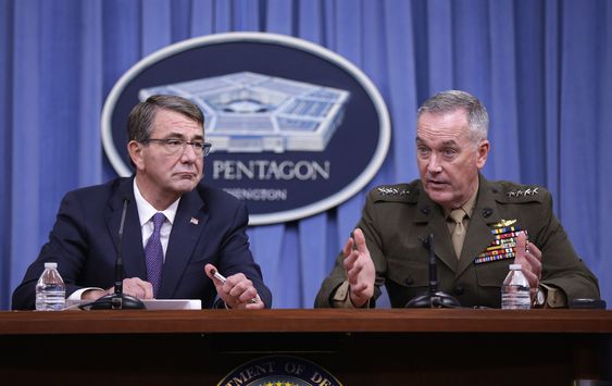 Carter listens at left as Joint Chiefs Chairman Gen. Joseph Dunford speaks during a news conference at the Pentagon Friday