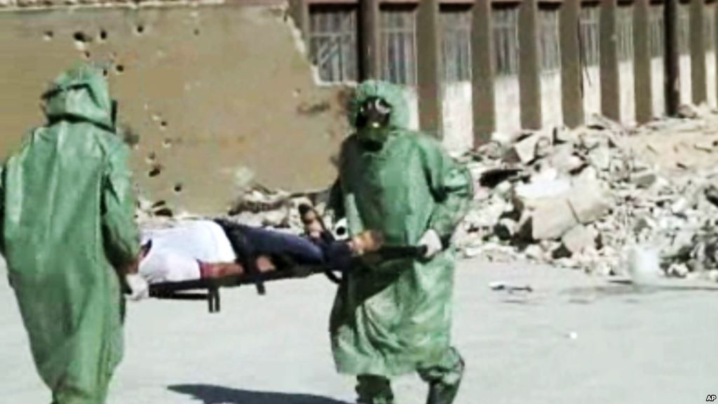 FILE- People in protective suits and gas masks conduct a drill on how to treat casualties of a chemical weapons attack in Aleppo Syria. Islamic State fighters reportedly fired rockets loaded with mustard gas into a town north of Baghdad late Tuesday and