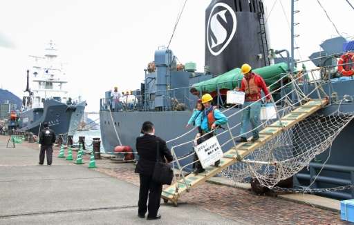 Workers disembark from a whaling ship at the port of Shimonoseki in western Japan