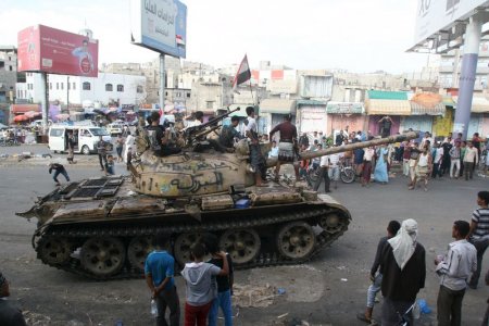 Pro-government fighters ride on a tank in the Bir Basha neighbourhood after they took the area from Houthi fighters in Yemen's southwestern city of Taiz