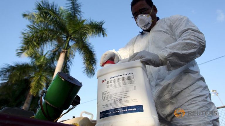 A health worker prepares insecticide before fumigating a neighborhood in San Juan in this