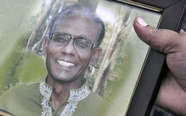 A man holds a portrait of Bangladeshi professor Rezaul Karim Siddique who was hacked to death by unidentified attackers in Rajshahi