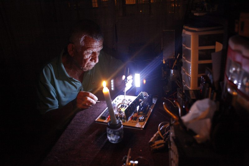 A man repairs a device during a power outage in San Cristobal Venezuela 26 April 2016