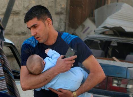 A man with a baby flees an airstrike in Aleppo