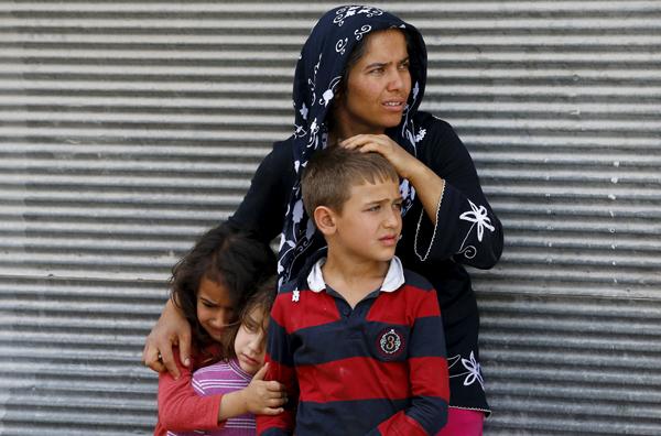 A mother and her children react after two rockets hit the Turkish town of Kilis near the Syrian border Turkey Sunday