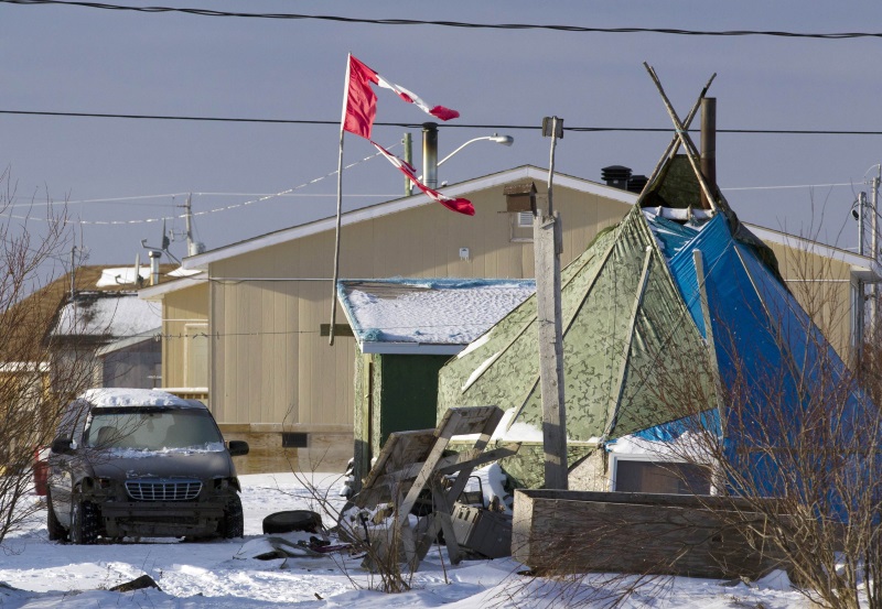 A tattered Canadian flag flies over a teepee in Attawapiskat