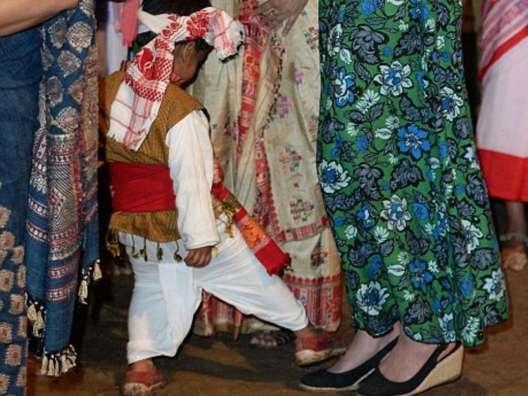 A three-year-old boy attempts stepping on Kate's feet at a fireside festival