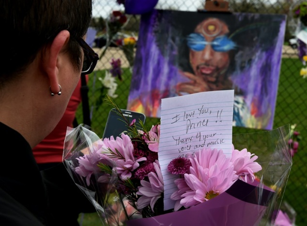 An Prince fan holds flowers outside the Paisley Park compound in Minneapolis Minnesota