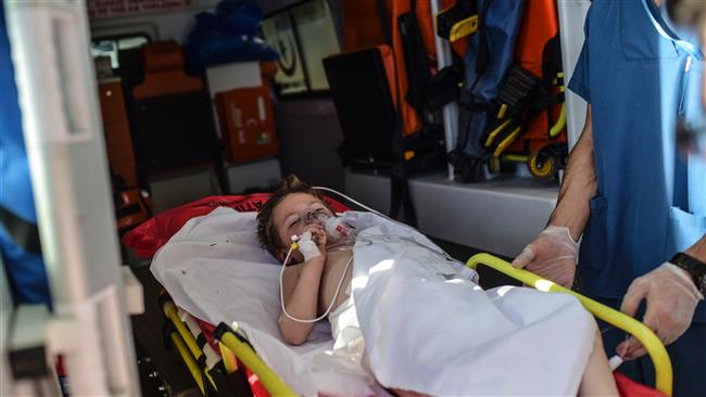 An injured child of northern Syria is carried on a stretcher at the southern Turkish border town of Kilis hospital