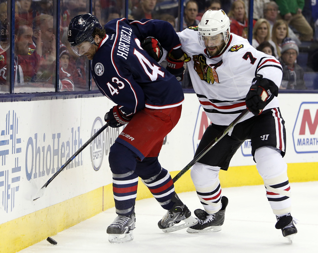 Columbus Blue Jackets Scott Hartnell left keeps the puck away from Chicago Blackhawks Brent Seabrook during the overtime period of an NHL hockey game Sat