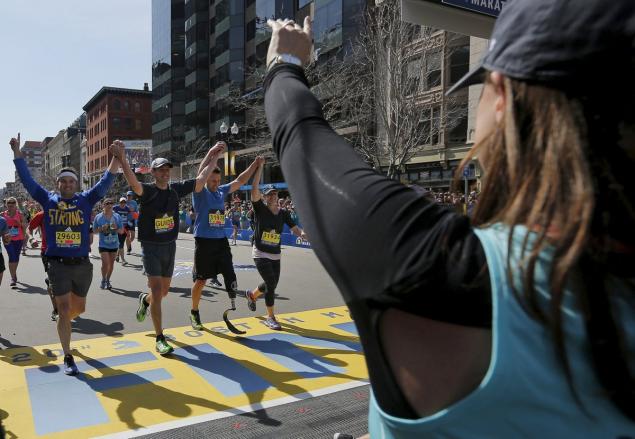 Boston Marathon bombing survivor Jessica Downes cheers as her husband and marathon bombing survivor Patrick finishes the 120th running of the Boston Marathon