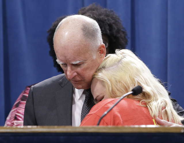 ASSOCIATED PRESS           Gov. Jerry Brown was hugged by Holly Dias a Burger King employee who praised Brown’s announcement of proposed legislation to increase the state’s minimum wage to $15 per hour by 2022 during a March 28