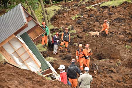 Rescuers guide dogs to search for victims buried in a landslide due to the recent earthquakes in the village of Minami Aso in Kumamoto prefecture on April 18. Rescuers intensified efforts on April 18 to find 10 people still missing in a devastated village