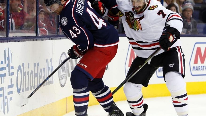 Columbus Blue Jackets&#x27 Scott Hartnell left keeps the puck away from Chicago Blackhawks&#x27 Brent Seabrook during the overtime period of an NHL hockey game Saturday