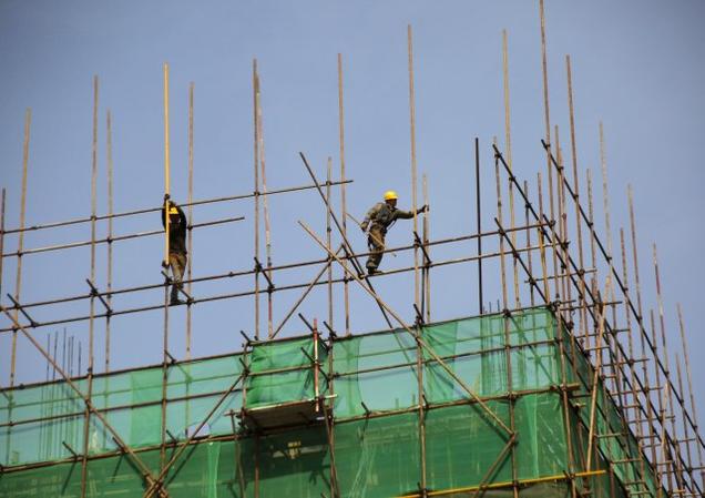 Labourers work on a scaffolding of a construction site at an industrial zone in Beijing China