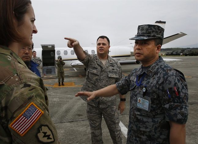 Col. Masahiro Sugawara Joint Staff Council of Japan Self Defense Force right speacks with Maj. Jack E. Beene of U.S. Air Force center as Maj. Jacqueline Hearne U.S. Army PAO left looks on upon Sugawara’s arrival at the Japan Ground Self Defense