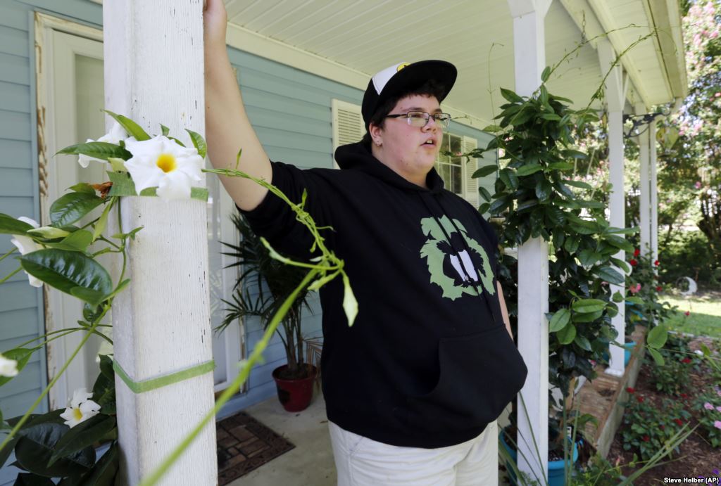 FILE- Gavin Grimm leans on a post on his front porch at his home in Gloucester Virginia in August 2015. Grimm is a transgender student whose demand to use the boys&#39 restrooms has divided the community and prompted a lawsuit