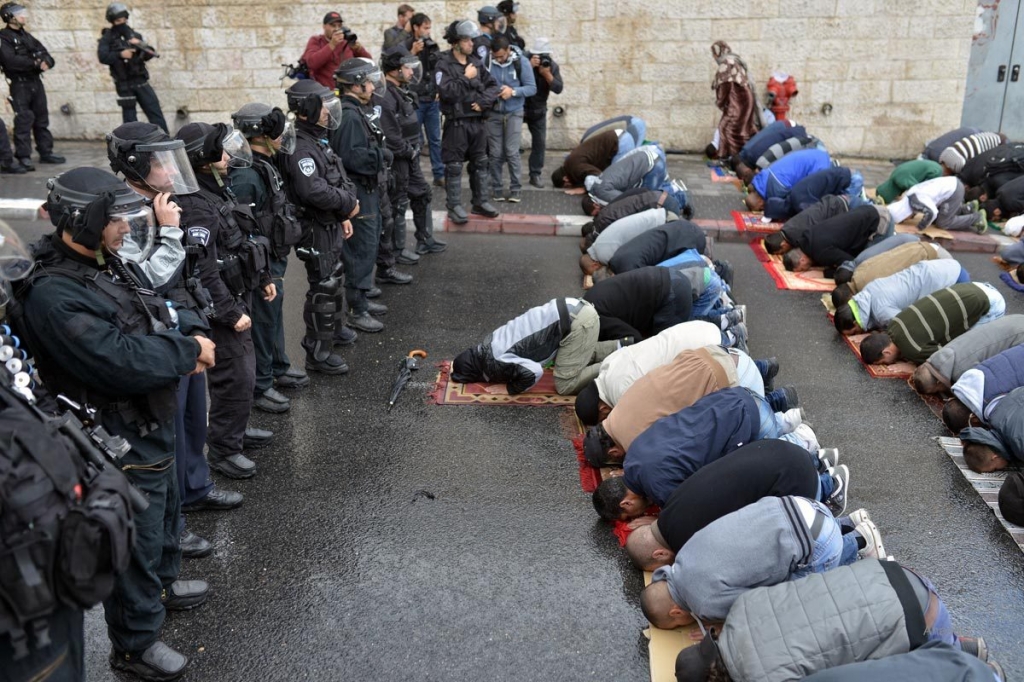 Palestinians performing prayer on street due to closure of al Aqsa mosque with soldiers gurading