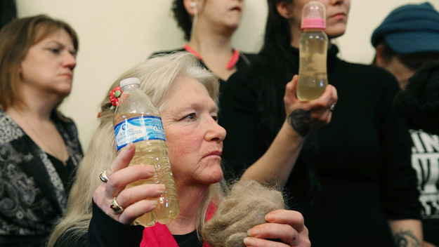 Flint residents Gladyes Williamson holds a bottle full of contaminated water